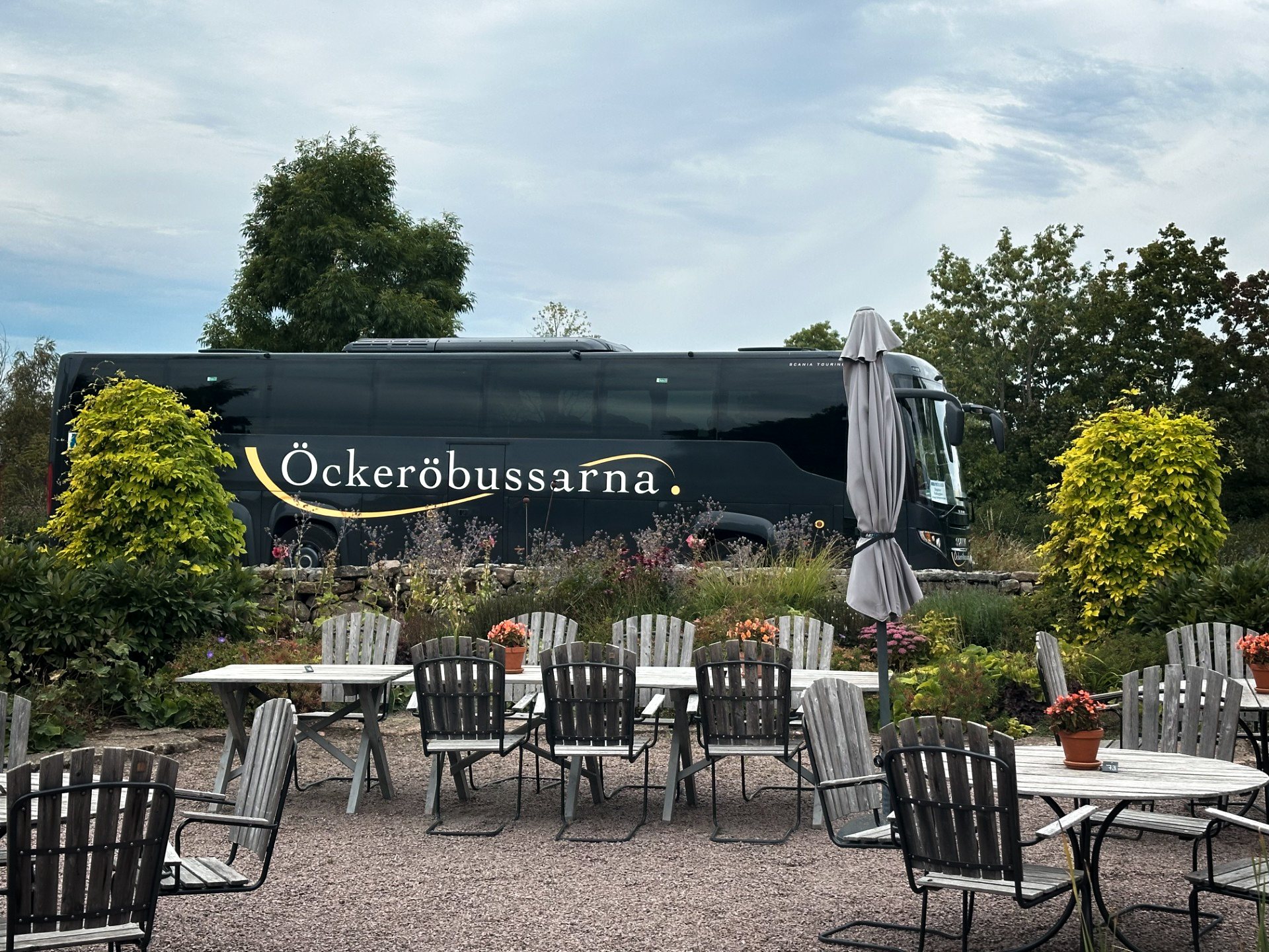 An Öckeröbussarna coach parked by an outdoor café