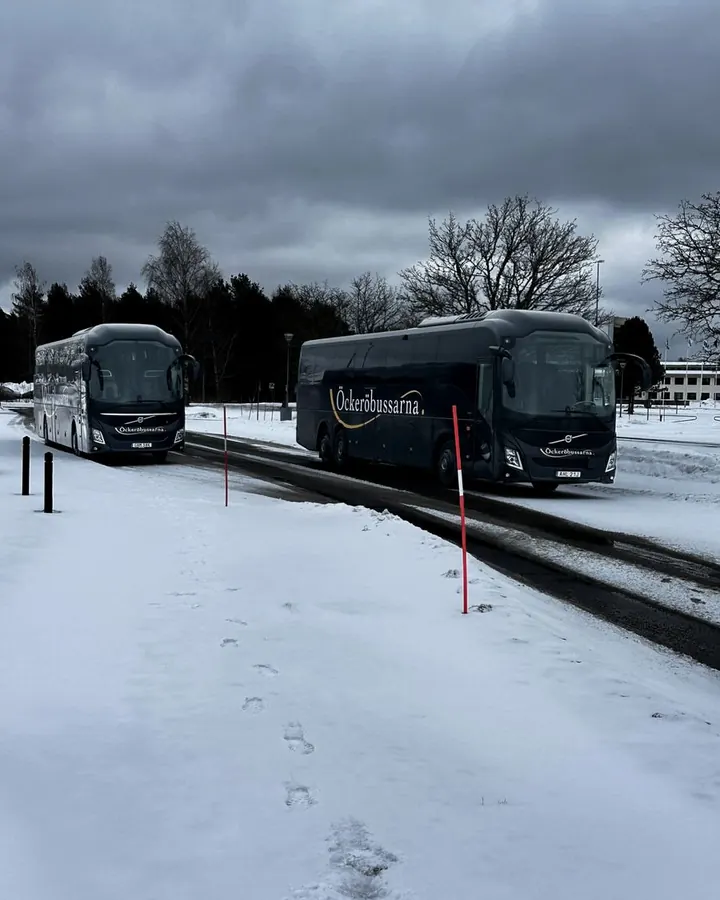 Två av Öckeröbussarnas bussar på en snöig väg