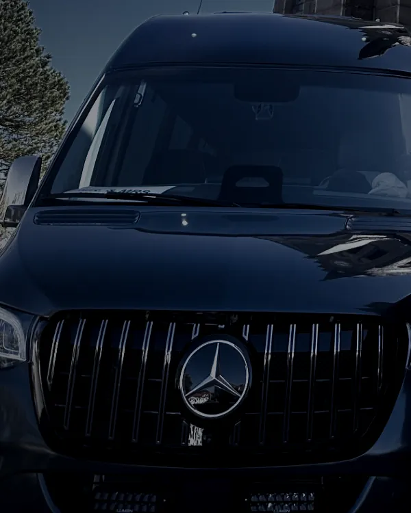Mercedes-emblemet på den svarta Sprinterns front.