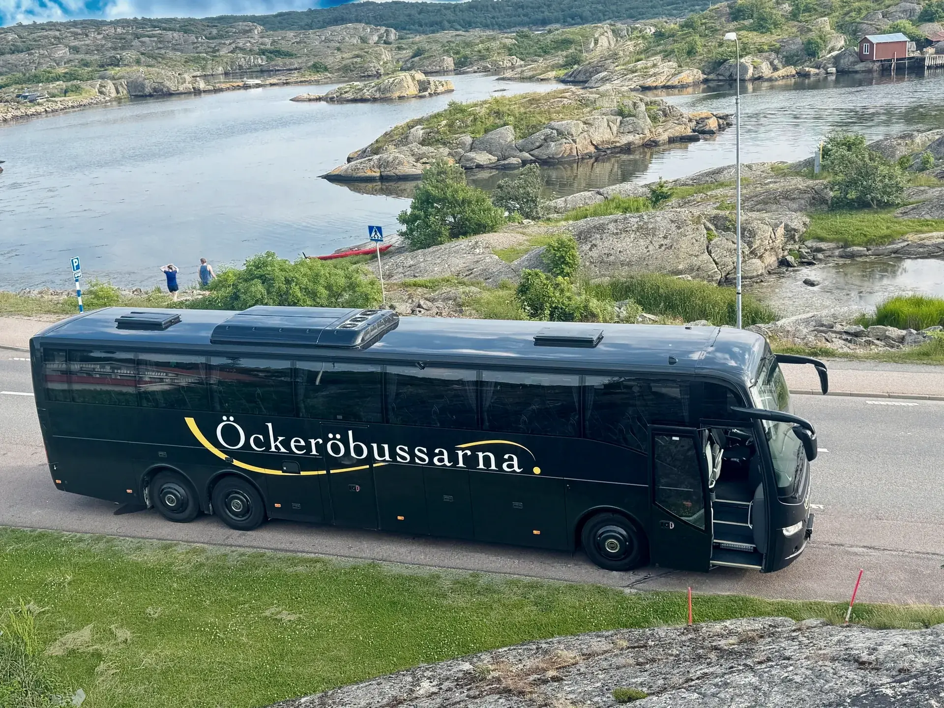 Öckeröbussarnas buss vid klipporna och vattnet i skärgården
